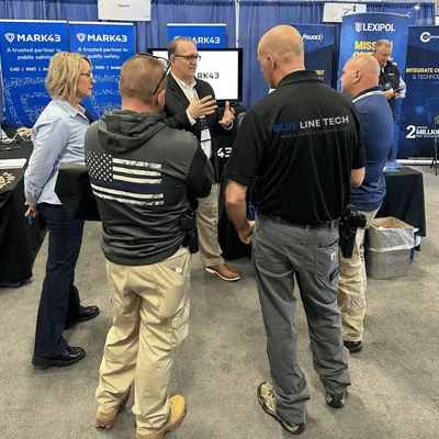 Officers talking with the Blue Line Tech team at a trade show