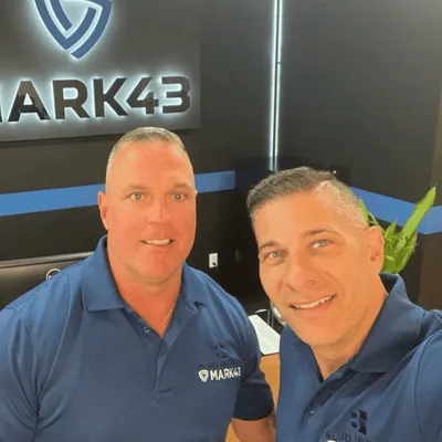 Two Blue Line Tech partners in front of a Mark43 sign