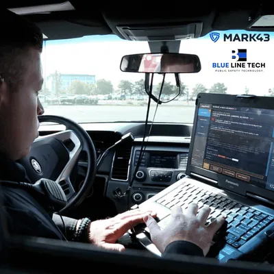 Officer using Mark43 on a laptop in a patrol car